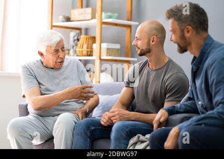 Grandpa Talking With Grandson And Son. Three Generations Family Stock Photo