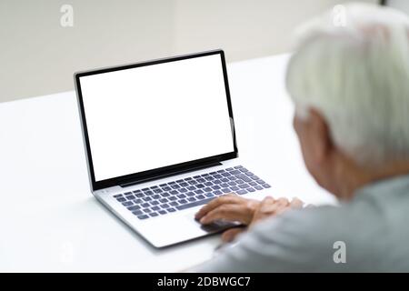 Close-up Of Senior Man Using Laptop Showing Blank Screen At Home Stock Photo