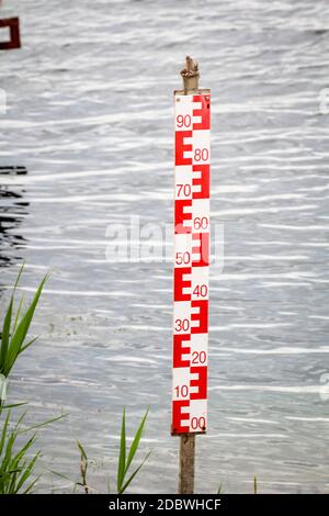 A yardstick for measuring the water level. Water level measurement on a body of water. Stock Photo