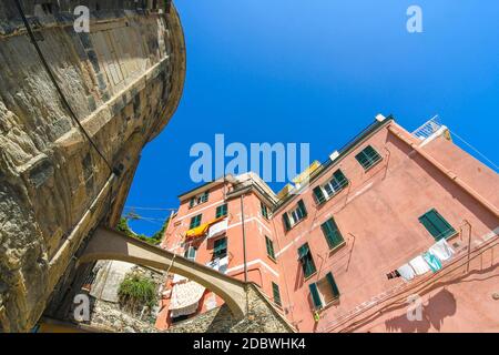 View on the beautiful colourful houses with clothes drying in the sunny daylight in Cique Terre, Italy. Stock Photo