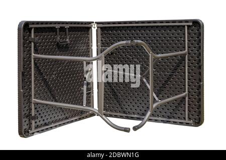 Folding table isolated. Close-up of a portable folding outdoor plastic table in rattan look for camping, garden, party or terrace isolated on a white Stock Photo