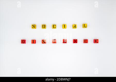 Yellow and red wooden cubes with message Social Distancing isolated on white background Stock Photo