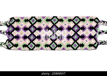 Woven DIY friendship bracelet handmade of embroidery bright thread with knots isolated on white background. Stock Photo