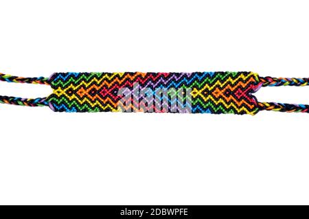 Woven DIY friendship bracelet handmade of embroidery bright thread with knots isolated on white background. Stock Photo