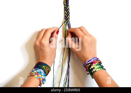 Process Of Weaving Knot For Diy Friendship Bracelet Pigtail Female Hands  With Many Handmade Bracelets On Wrists Step By Step White Background With  Copy Space Stock Photo - Download Image Now - iStock