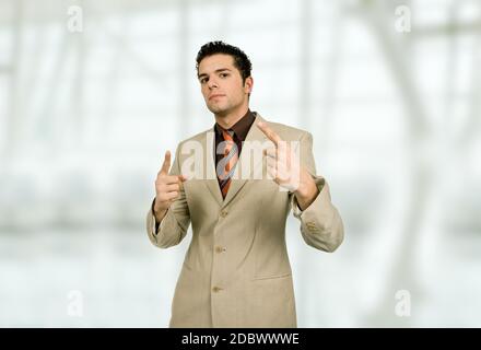 Businessman in a suit pointing up at the office Stock Photo