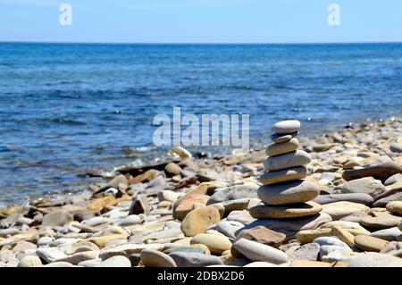 Pyramid made of stones on the shore of Japanese sea, Russia. Copy space. Stock Photo