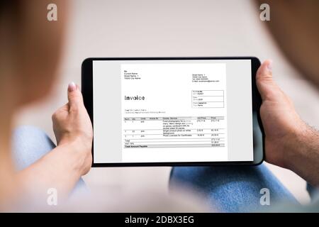 Young Couple Looking At E Invoice On Tablet Stock Photo