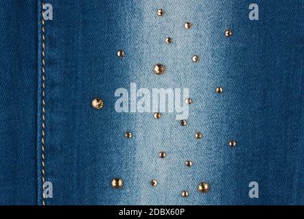 Yellow seam and yellow rhinestones on denim, background, texture Stock Photo