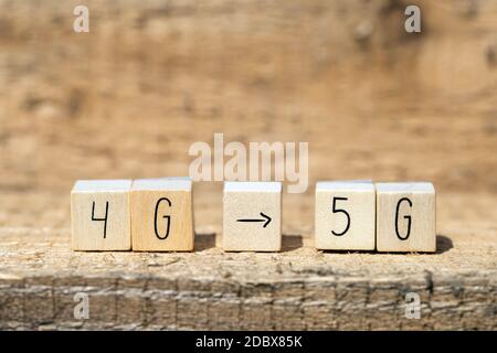 Wooden cubes From 4g To 5g with black arrow pointing On wooden background, mobile or technology concept closeup Stock Photo