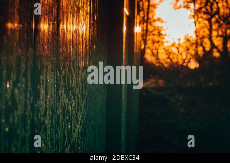 A Bright Orange Sunrise Casting a Reflection off of a Frost Covered Fence Stock Photo