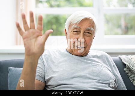 Elder Man Waving Hello In Video Conference Stock Photo