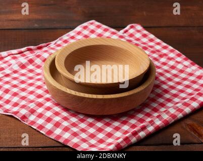 empty round brown wooden plate stands on brown table, top view Stock Photo
