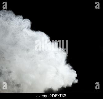 cloud of white wheat flour on a black background, particles fly in different directions, explosion and splash, close up Stock Photo