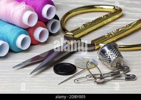 A pair of scissors and sewing supplies thimble cotton pins Stock Photo