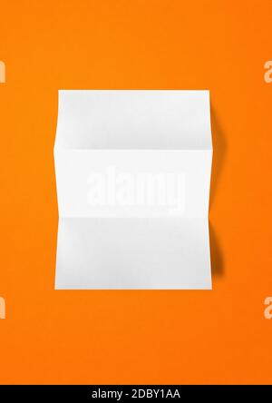 Blank folded White A4 paper sheet mockup template isolated on orange background Stock Photo
