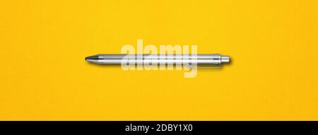 Steel metal pen isolated on yellow background banner Stock Photo