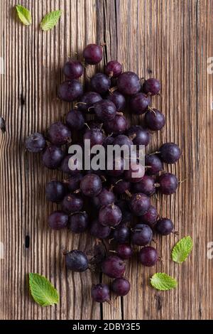 Heap of black currant on wooden background Stock Photo