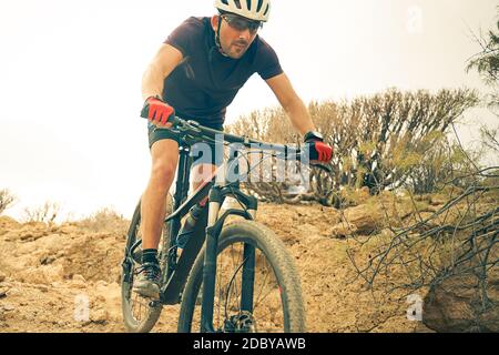 Cyclist in violet Riding the Mountain Bike on the spring Enduro Trail. Extreme Sport and Enduro Biking Concept. Stock Photo
