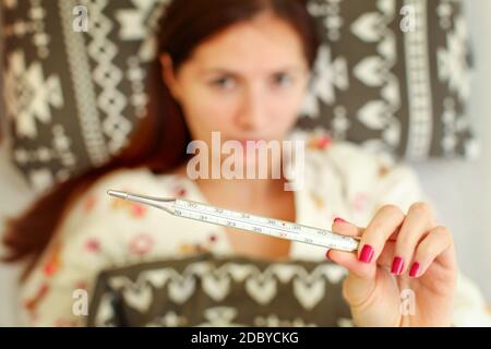 A Young Person Is Holding A Thermometer With High Temperature High