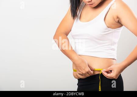 Asian mother woman use section postpartum scar measuring waist stretch mark loose lower abdomen skin she fat after pregnancy baby birth isolated on wh Stock Photo