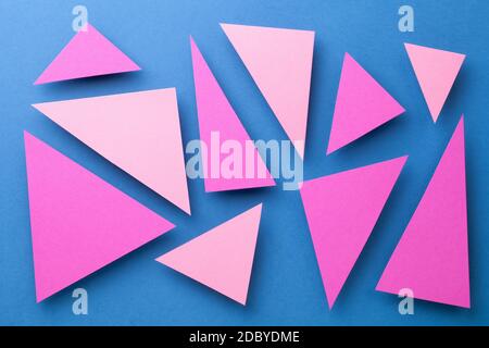 Abstract composition over blue paper background with pink triangular shapes. Minimal style. Top view Stock Photo