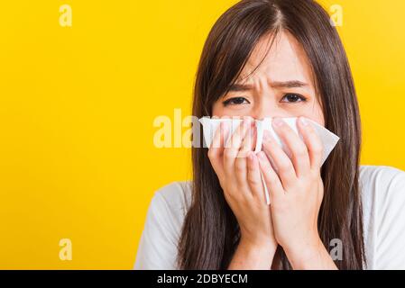 Portrait of Asian beautiful young woman sad she crying wipe the mucus with tissue, Close up of pretty girl sneezing sinus using towel to wipe snot fro Stock Photo