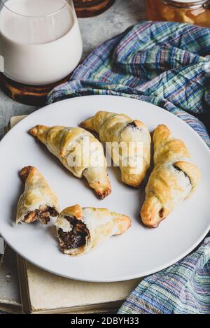 Fresh baked croissants stuffed with nuts and chocolate spread for breakfast Stock Photo