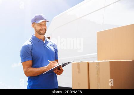 Professional Van Courier Unloading Boxes From Truck Stock Photo