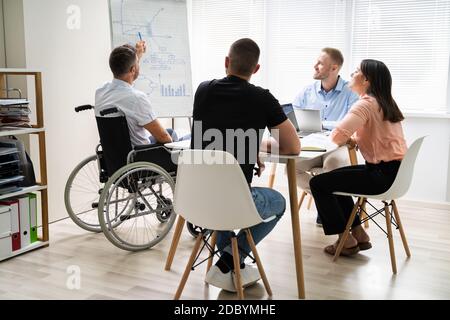 Wheelchair And Disability At Office. Giving Presentation At Work Stock Photo