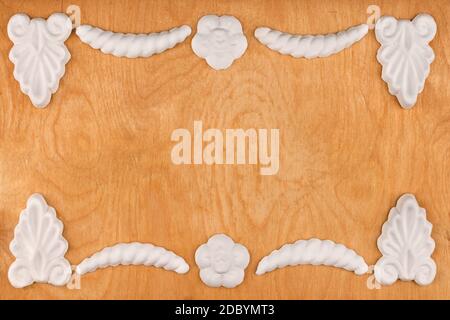 Luxury frame made of white stucco plaster, lying on a light wood, with a place for your text Stock Photo