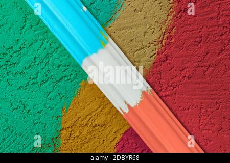 Rough plaster surface painted in a bright color. Variations of harmony and color compatibility in the repair. A sample of paint mixing on the wall wit Stock Photo