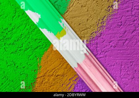 Rough plaster surface painted in a bright color. Variations of harmony and color compatibility in the repair. A sample of paint mixing on the wall wit Stock Photo