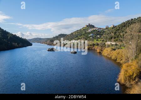 View of the Belver Castle (Castelo de Belver) and village from the middle of the Tagus River in Portugal; Concept for travel in Portugal Stock Photo