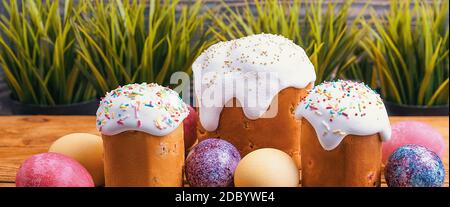 Easter cakes and Easter colored eggs on a wooden background. Religious holiday of bright Easter. Stock Photo