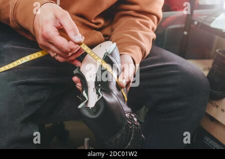 Shoemaker making shoe using shoemaker tools in workshop Stock Photo