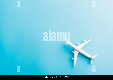 World Tourism Day, Top view flat lay of minimal toy model plane, airplane, studio shot isolated on a blue background, accessory flight holiday concept Stock Photo