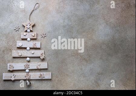 Wooden Christmas tree and Christmas toys. Alternative Christmas tree. Zero waste and eco-friendly festive decoration concept. Flat lay. Copy space. Stock Photo