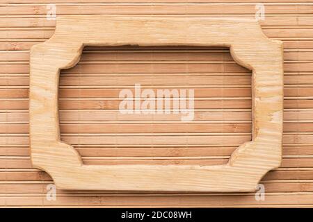 Beautiful frame, sign board cut from a solid board, lies on a bamboo mat. Close-up. Top view Stock Photo
