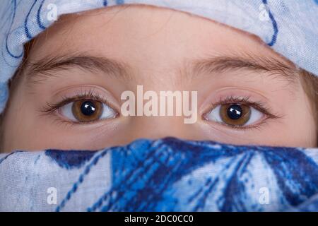 young girl with a veil covering her, close up, studio picture Stock Photo