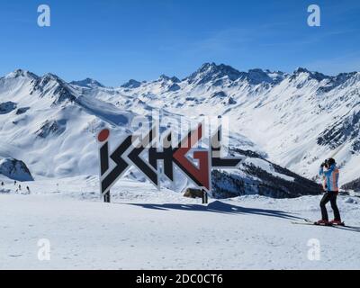 Skier taking a photograph of the Ischgl logo on the top of Pardatschgrat with clear blue sky, Ischgl-Samnaun ski resort, Austria Stock Photo