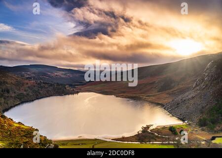 Dramatic sunset at Lake Lough Tay or The Guinness Lake in County Wicklow where Vikings village, Kattegat was located, Wicklow Mountains, Ireland Stock Photo