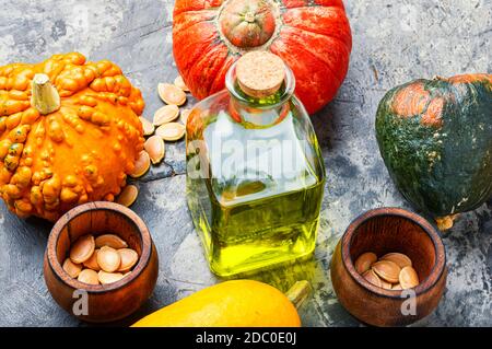 Pumpkin oil in bottle,raw pumpkin and pumpkin seeds.Autumn food Stock Photo
