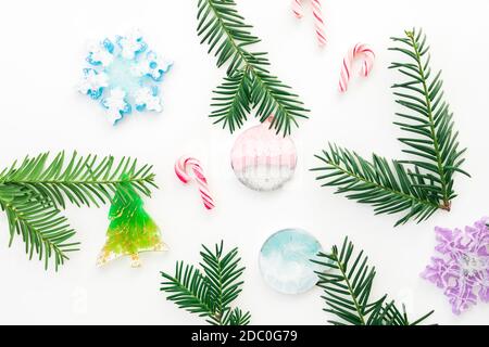 Christmas toys with candy canes and evergreen tree branches on white background. Flat lay, top view Stock Photo