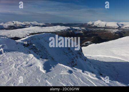 Winter on Helvellyn , snowy landscape with crags,Brown Cove Crags on Helvellyn lower Man looking towards Thirlmere and Skiddaw , Lake District,Cumbria Stock Photo