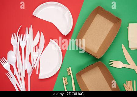 non-degradable plastic waste from disposable tableware and a set of dishes from environmental recycled materials on a green background. Concept of rej Stock Photo