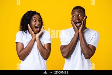 Surprised black couple screaming and looking at each other Stock Photo