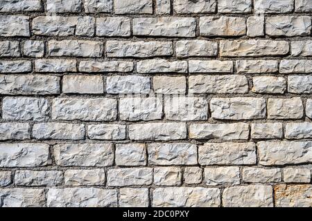 Background from an uniform natural stone wall Stock Photo