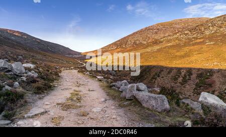 Hiking on winding trail in the valley between Slieve Donard and Rocky Mountain in Mourne Mountains, County Down, Northern Ireland Stock Photo