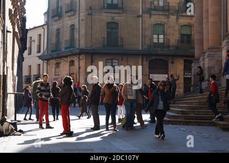 Some people walking on Compañía street, in between Casa de las Conchas and La Clerecía, Salamanca, Castille and Leon, Spain Stock Photo